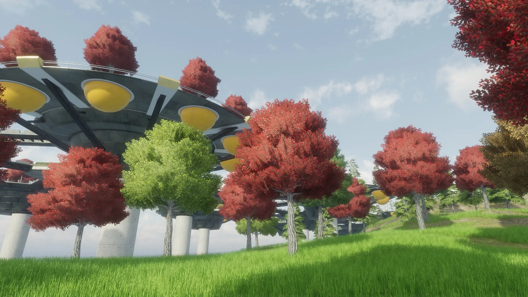 Red and green trees on grass beside a round platform raised on pillars, under a blue sky with light clouds.